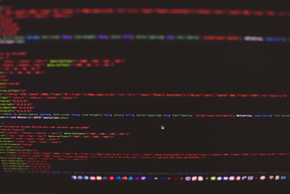 A close-up image of a laptop computer displaying lines of green, blue, and purple code on a black background, placed on a wooden desk. Next to the laptop, there is a ceramic mug with an off-white back